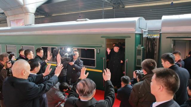 North Korean leader Kim Jong Un waves from a train in Beijing