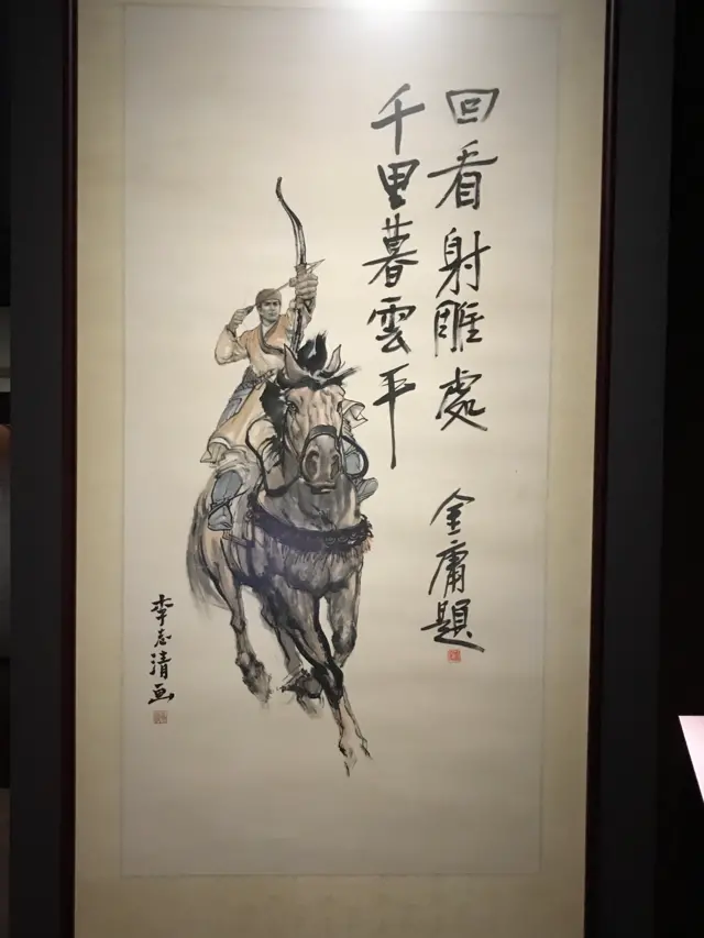 ลายมือเขียนของกิมย้ง ประกอบกับภาพนักบู๊บนหลังม้าน้าวคันธนู