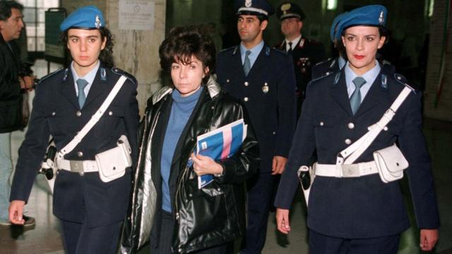 Patrizia Reggiani entre oficiais italianos em 1998, no período de seu julgamento