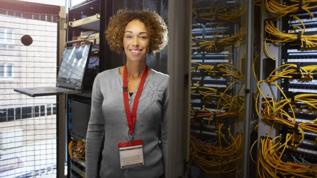 Женщина в окружении серверов и проводов