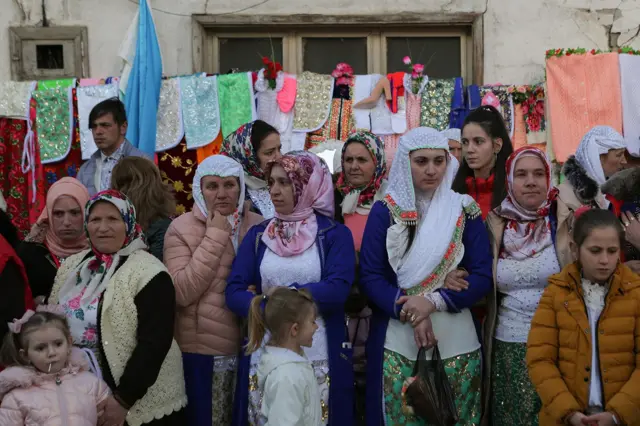 Žene odevene u tradicionalnu nošnju Pomaka posmatraju kolo u centru Ribnova.