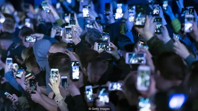 Pessoas com celular na mão