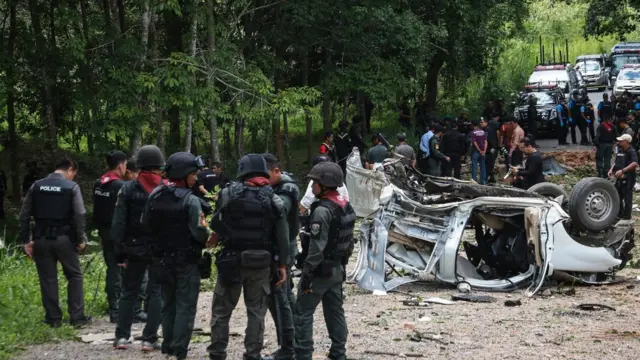 Thai police and army personnel inspect the scene of a bomb attack which left three police officers dead in Thailand's restive southern province of Yala on September 23, 2016