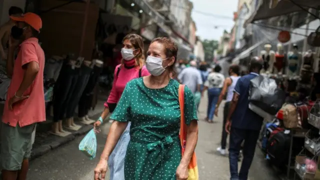 Pessoas caminhandobetsul patrociniomáscara no Rio