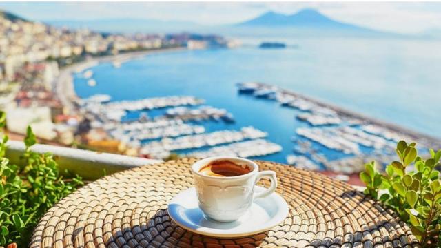 Una mesa y un café, con vista a la bahía de Nápoles