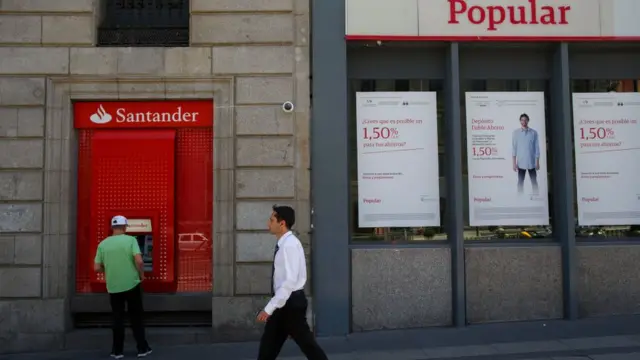 Hombre cruza frente a banco popular