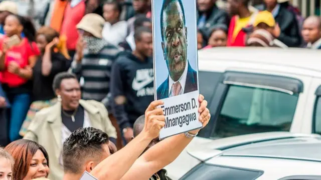 ประชาชนที่มาประท้วงเรียกร้องให้ประธานาธิบดีโรเบิร์ต มูกาเบ ลาออก ชูป้ายสนับสนุนมนังกากวาที่เพิ่งถูกให้ออกจากตำแหน่งรองประธานาธิบดี ก่อนหน้าการยึดอำนาจ