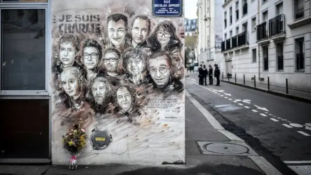 पेरिस में एक जगह दीवार पर बनाई गई शार्ली एब्डो के मारे गए कर्मचारियों को समर्पित एक कलाकृति