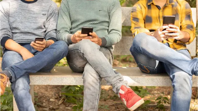 ਮੋਬਾਈਲ ਵਰਤ ਰਹੇ ਤਿੰਨ ਲੋਕਾਂ ਦੀਆਂ ਲੱਤਾਂ