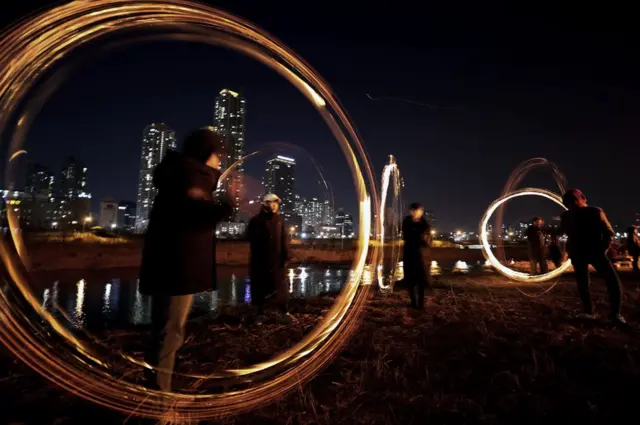 Peoأشخاص يشاركون في لعبة شعبية تسمى جويبولنوري بسيول في كوريا الجنوبية احتفاء ببزوغ القمر بمناسبة حلول السنة الجديدة بهدف طرد الحشرات والحظ السيء.