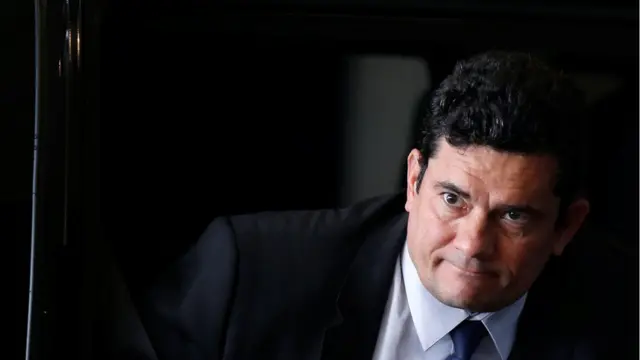 Sérgio Moro aparecedono da luva betterno e olhando para frente