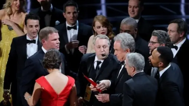 ग़लती से 'ला ला लैंड' फ़िल्म के नाम की घोषणा के बाद वॉरेन बेटी सही फ़िल्म 'मूनलाइट' के नाम वाले कार्ड के साथ.