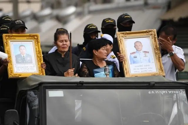 ญาติของผู้ที่เสียชีวิตถือรูปของผู้ที่เสียชีวิต