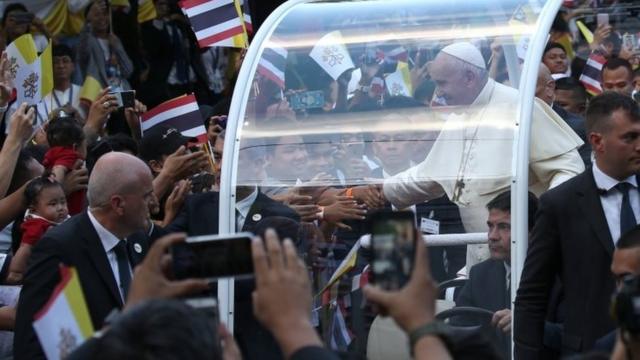 Pope Francis greets to well-wishers from the pope mobile as he arrives at Assumption Cathedral to celebrate a Holy Mass in Bangkok.