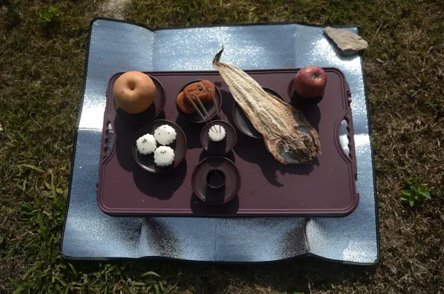 ของที่นำมาเซ่นไหว้แสดงความรำลึกถึงชาวเกาหลีเหนือที่เสียชีวิตเพราะเรือล่มก่อนขึ้นฝั่งไทยและได้พบกับอิสรภาพที่แท้จริง