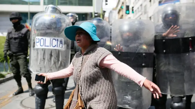 Una mujer protesta frente a agentes de policía en Bolivia