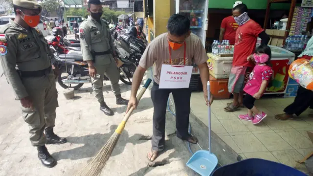 Pelanggar PSBB pra Adaptasi Kebiasaan Baru (AKB) membersihkan ruang publik di kawasan Pasar Cibinong, Kabupaten Bogor, Jawa Barat, Rabu (29/07).