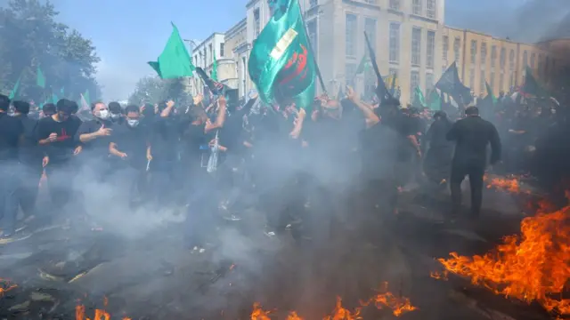 Iranian and Iraqi Shiite Muslims run past a burning tent during the reenactment of the events of the tenth day of the month of Muharram which marks the peak of Ashura, in the Iranian capital Tehran on August 30, 2020. - Ashura is a period of mourning in remembrance of the seventh-century martyrdom Imam Hussein, who was killed in the battle of Karbala in modern-day Iraq, in 680 AD
