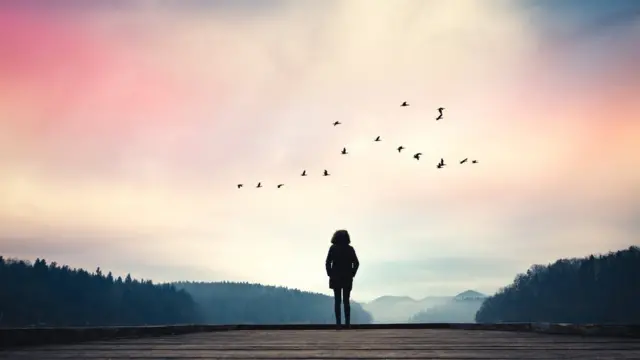 Mujer al borde de un lago sola