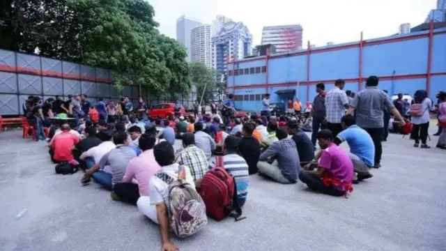 অবৈধ শ্রমিক-বিরোধী অভিযানে রাস্তার পাশে বসিয়ে রাখা হয়েছে আটককৃতদের। কৃয়ালালামপুর, জুলাই ২০১৮