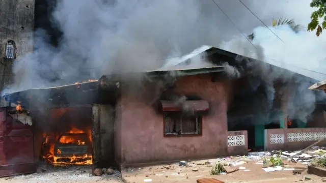 Une maison en flammes, lors d'une manifestation contre la tenue des élections, à Conakry