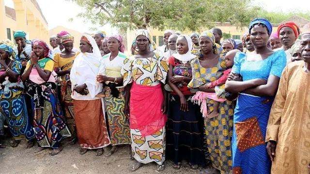 This picture taken on March 5, 2015 the mothers of Chibok Schoolgirls siezed by Boko Haram Islamist fighters on the evening of April 14, 2014, wait the arrival of Minister of Finance Ngozi Okonjo-Iweala to flag off rebuilding of schools burnt by the militants in Chibok, Northeastern Nigeria
