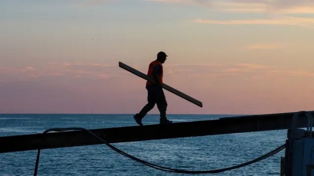 Hombre llevando cosas a su barco