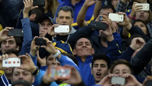 Aficionados usan sus teléfonos en el fútbol