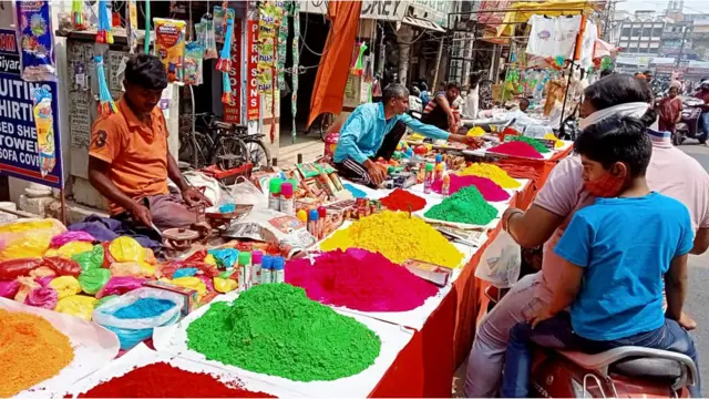 उत्तर प्रदेश की राजधानी लखनऊ में गुरुवार को गुलाल ख़रीदते लोग.