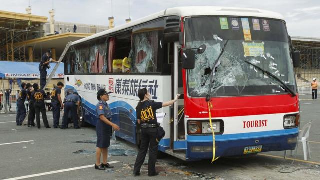 A member of the Philippine National Police (PNP) Scene of the Crime Operations (SOCO) inspects the damage to a tourist bus during their forensic examinations in Manila August 24, 2010. Philippine authorities defended on Tuesday their handling of a bus hostage crisis in which eight Hong Kong tourists were killed, but missteps were seen as signs of deeper deficiencies in a country beset by security problems.