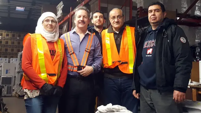 ጂም በድርጅታቸው ውስጥ ከሚሠሩ የተወሰኑ ሶሪያዊያን ስደተኞች ጋር