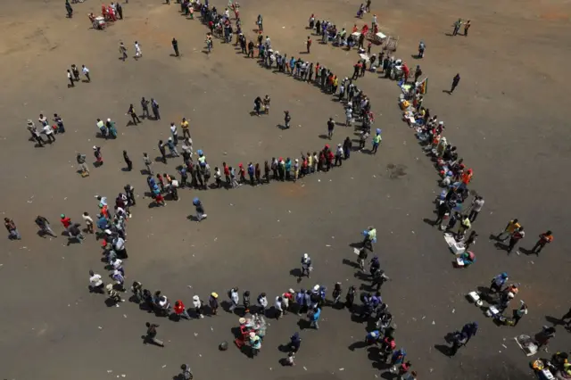 Shacabka ku nool caasimadda Zimbabwe ee Harare oo soo dhaweynta naxashka Mugabe saf dheer ugu jiro.garoonka kubadda ee Rufaro.