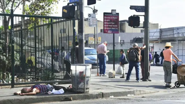 Un indigente está acostado en una acera en Los Ángeles