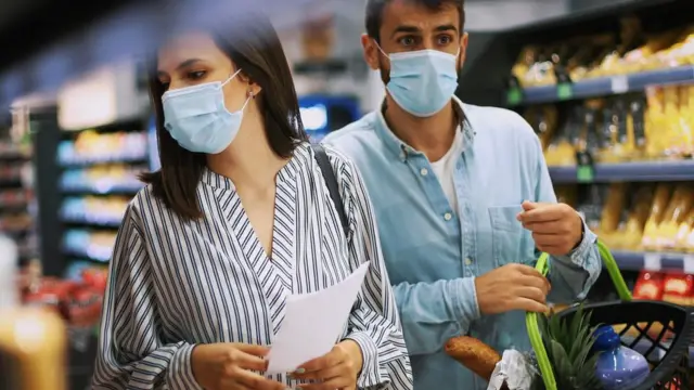 Casal faz compras no mercado durante pandemia