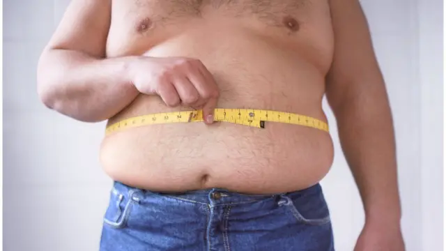 Hombre midiéndose la barriga