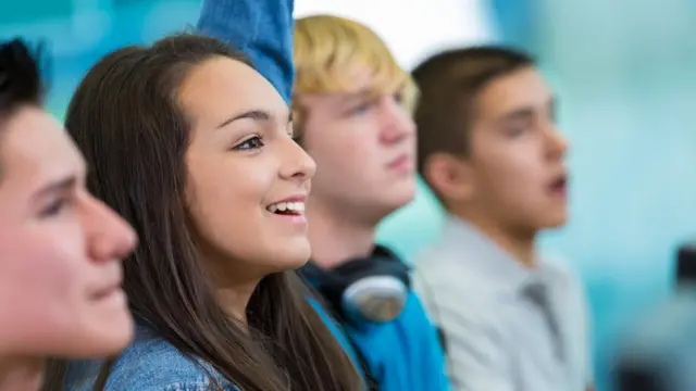 Aluna levantando a mão na classe