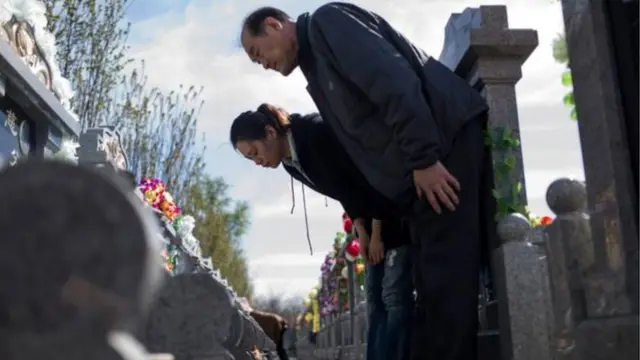 क़ब्र पर श्रद्धांजली देते चीनी