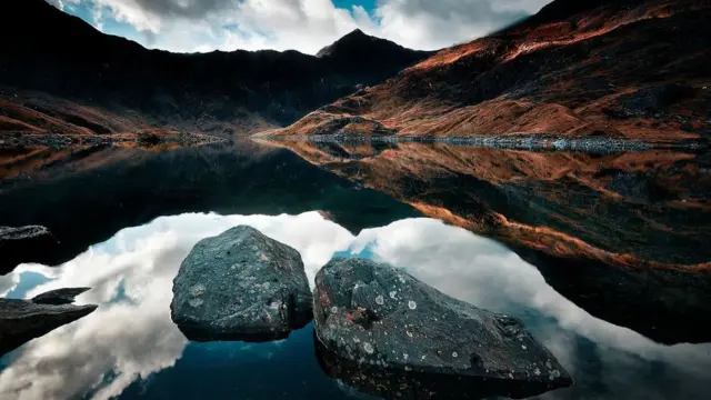 Un fino manto de hierbas de color cobre cubre las montañas frente al lago.