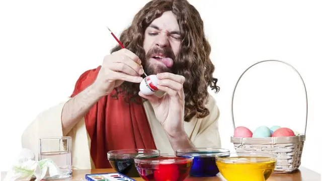 Hombre tratando de pintar un huevo con la lengua afuera