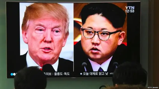 People watch a television news report showing pictures of US President Donald Trump (L) and North Korean leader Kim Jong Un at a railway station in Seoul on March 9, 2018