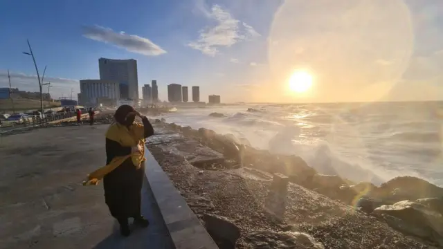 A Libyan woman stands on the shore of the Mediterranean Sea in the capital Tripoli on January 26, 2021.