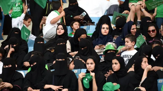 سعوديات يتابعن مباراة لكرة القدم بعد السماح لهن بذلك ضمن خطة إصلاحية لولي العهد السعودي محمد بن سلمان.