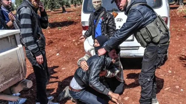 نیروهای ارتش آزاد سوریه در صف ورودی یکی از مردانی را که از عفرین گریخته بازجویی می‌کنند