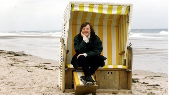 Angela Merkel sits a covered seat on the beach