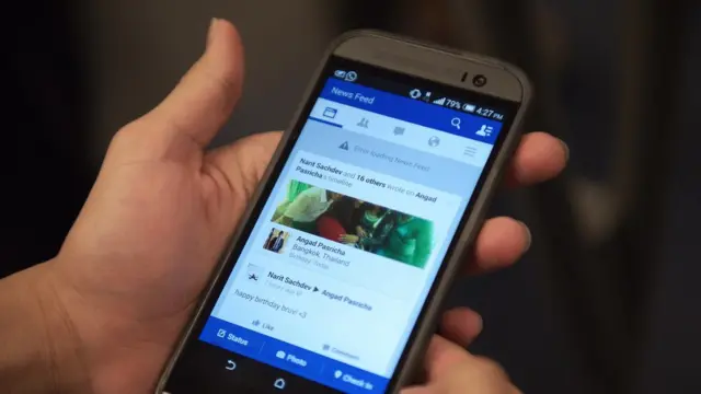 ผู้ใช้เฟซบุ๊กเช็คข่าวสารทางสมาร์ทโฟน