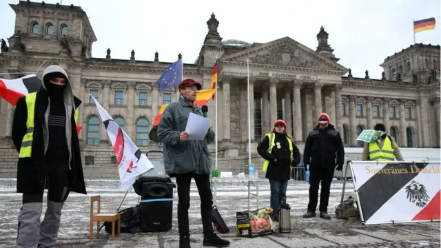 বাার্লিনে জার্মান পার্লামেন্ট ভবনের সামনে রাইশবুর্গার গোষ্ঠীর কয়েকজন বিক্ষোভকারী