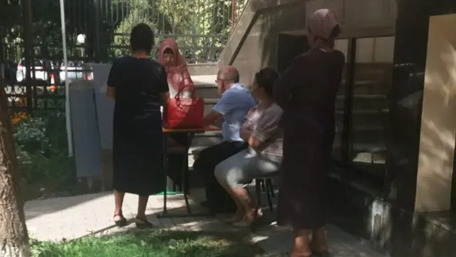 Ўқитувчи Абдурашид Абдуллаев бошчилигида ходимлар ҳижобли қизга уни ечиш бўйича "тушунтириш" олиб бормоқда.