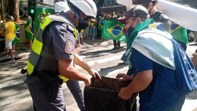 Foto enviada pela Secretaria de Segurança Pública mostrando policial revistando manifestante na Paulista nesta terça