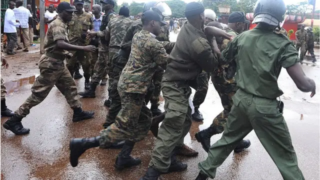 Des militaires qui ont l'air d'arrêter quelqu'un.