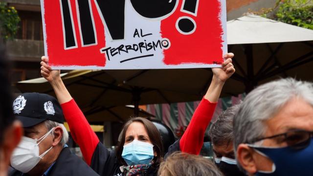 Mujer porta un cartel con el mensaje de "No al terrorismo".